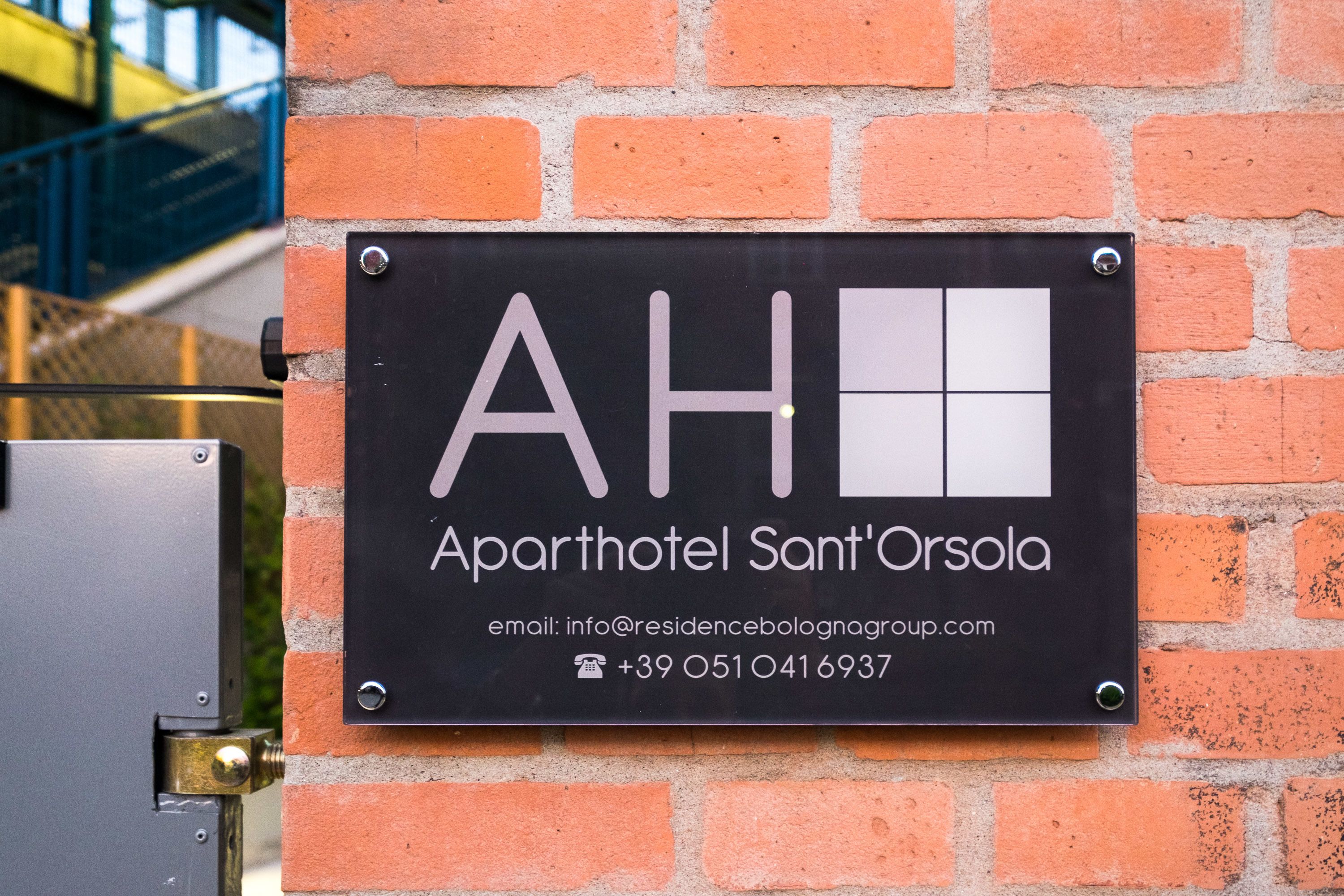 Schild mit der Aufschrift 'Aparthotel Sant'Orsola' und Kontaktinformationen.