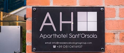 A sign for 'Aparthotel Sant'Orsola' with contact information.