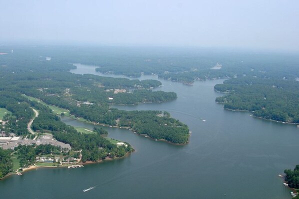 An aerial view of a coastal area with multiple islands, a marina, and surrounding greenery.