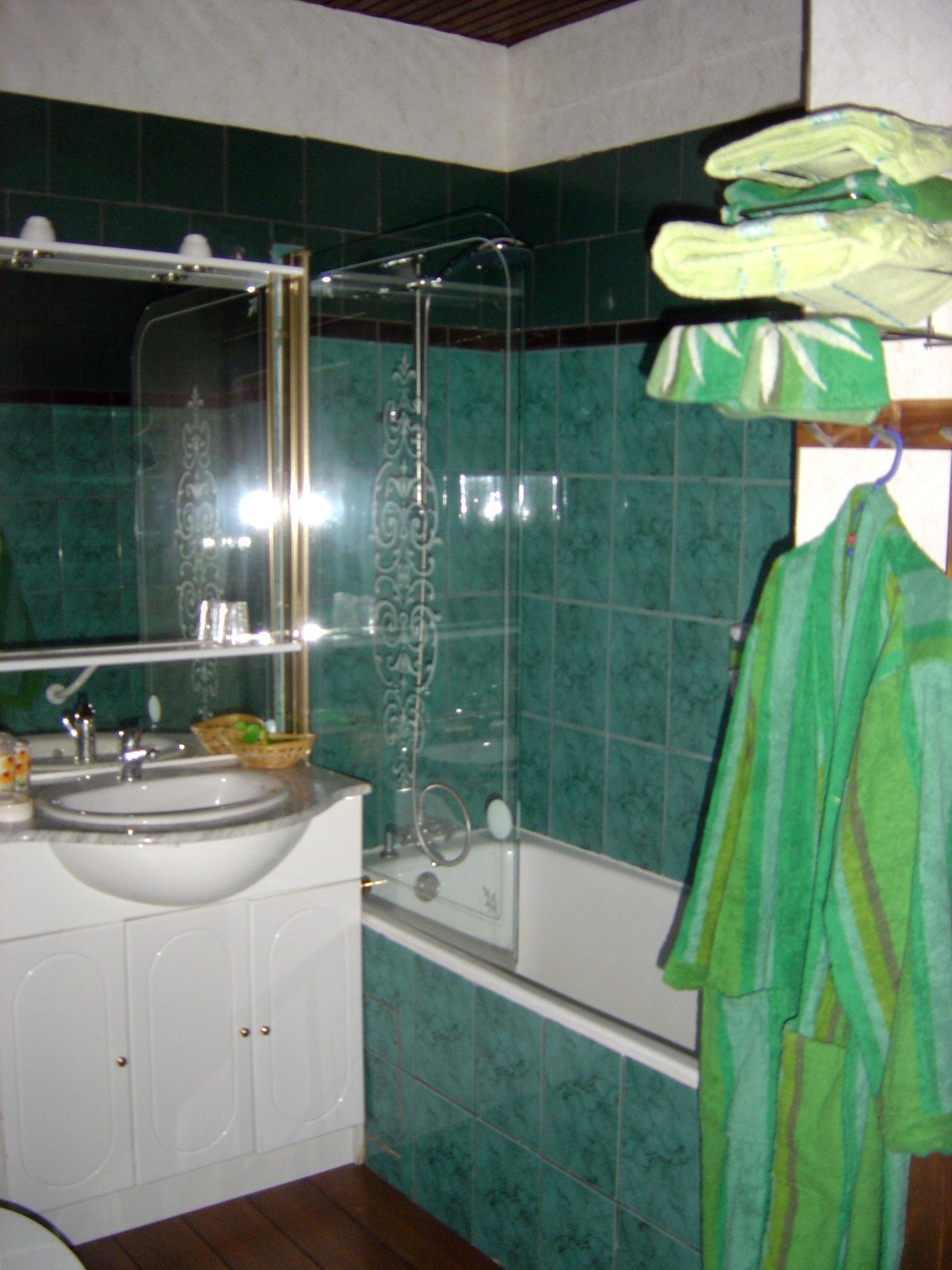 Un baño con lavamanos, espejo y bañera.