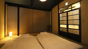 A traditional Japanese room with tatami flooring, shoji screens, and a low ceiling. - Chizuruan (Kyoto)