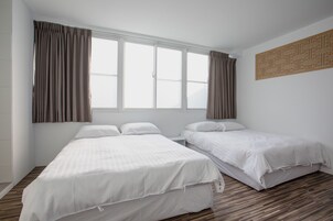 Habitación cuádruple | Edredones de plumas, escritorio, cortinas opacas y camas supletorias