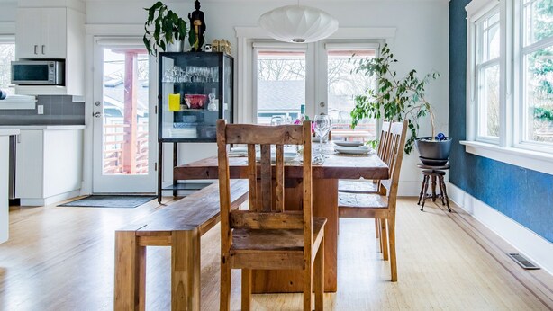 A modern kitchen with wooden furniture, a dining table, and a large window. - Sunny Family Home in Heart of Kitsilano with Mountain Views (Vancouver)