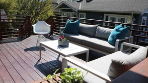 A deck with a sofa, chairs, and a table. - Sunny Family Home in Heart of Kitsilano with Mountain Views (Vancouver)