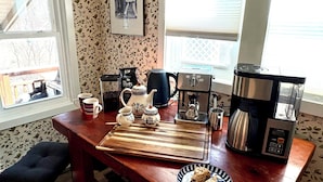 Eine Küchenarbeitsplatte mit Kaffeemaschine, Wasserkocher, Tasse und einem Teller mit Scones.