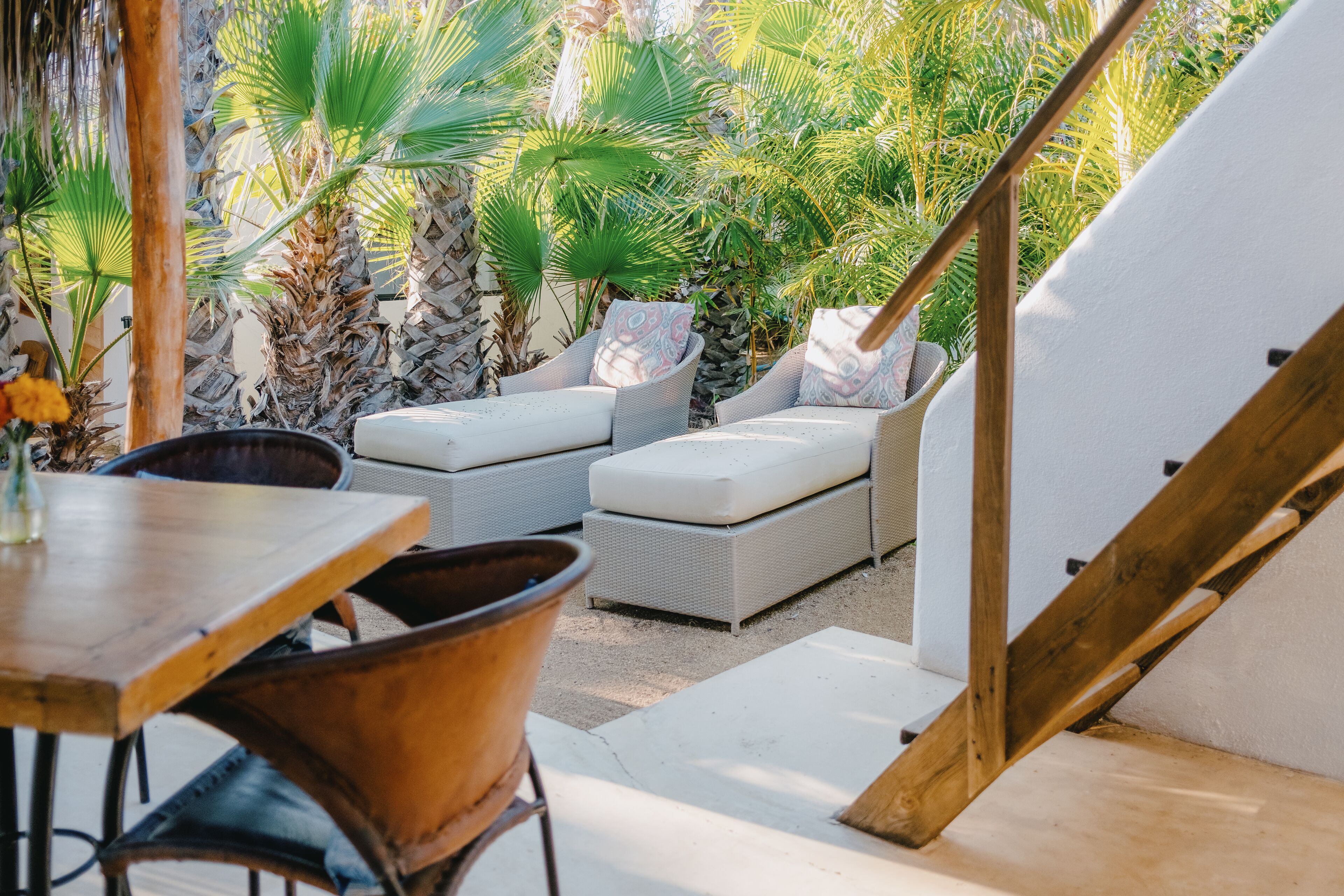 Ein Patio mit Korbmöbeln, einem Holztisch und einer weißen Zelthalle.