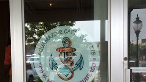 Eine Glastür mit einem marinen Logo und dem Schriftzug, dass sich das Etablissement in der 508 W. Marine Way, Suite 100 befindet.