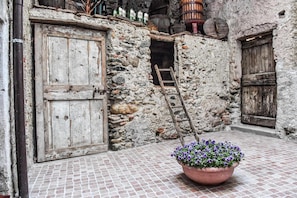 A rustic stone building with wooden doors and a tiled floor. - La Terra di Mingo (Vado Ligure)