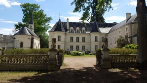 A large, historic building with a symmetrical facade, multiple windows, and a central entrance. - Château de Basché (Assay)