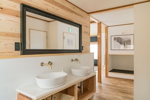 A bathroom with two sinks, a large mirror, wooden paneling, and a framed picture on the wall. - Nozawa Gondola Apartments (Nozawaonsen)