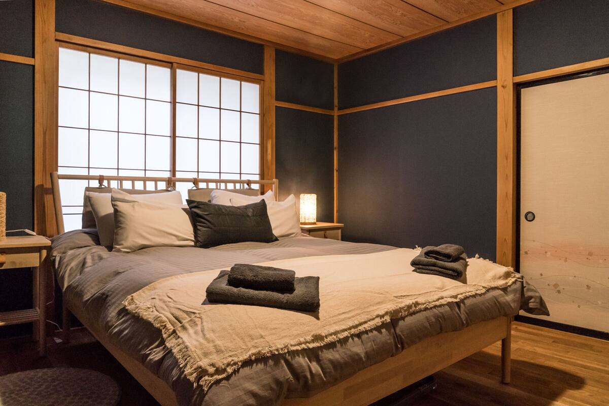 Un dormitorio con una cama grande, cabecera de madera y ventana con vistas.