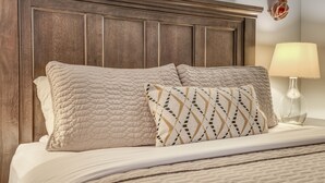 A neatly made bed with a quilted headboard, two pillows, and a bedside lamp. - S2 - Cowabunga - Surf Inn - 2 Bed 2 Bath (Netarts)