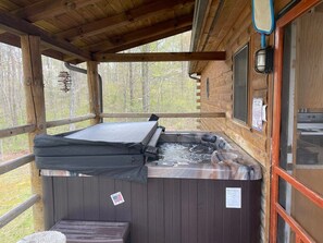 A hot tub with a cover, wooden walls, and a window. - Pet friendly, hot tub, close to Hocking Hills! (McArthur)