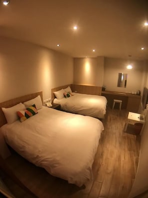 A hotel room with two beds, a small desk, and a mirror. - Rainbow House (Yuchi)