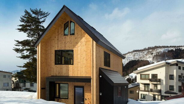 A modern wooden house with a sloped roof, large windows, and a door. - Harvest Eco House (Nozawaonsen)