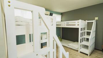 A room with bunk beds and a staircase.