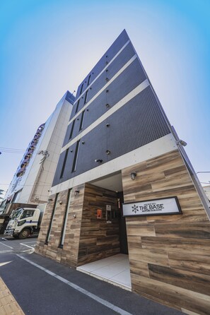 A modern building with a prominent entrance labeled 'The Base' and a sign for 'Apartment Hotel Sapporo Susono'. - The Base Sapporo Susukino (Sapporo)