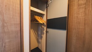Guarda-roupa de madeira com cabideiro interior.
