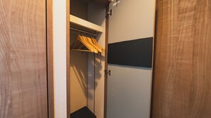 Guarda-roupa de madeira com cabideiro interior.