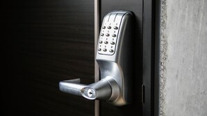 A modern door lock with a numeric keypad and a keyhole. - The Base Sapporo Susukino (Sapporo)
