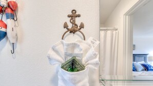 Ein Handtuchhalter mit einem weißen Handtuch und einer grünen Handdesinfektionsflasche.