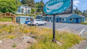 Schild des Whale Inn mit einem Wal-Grafik, in ländlicher Umgebung mit Parkplatz und Gebäuden im Hintergrund.