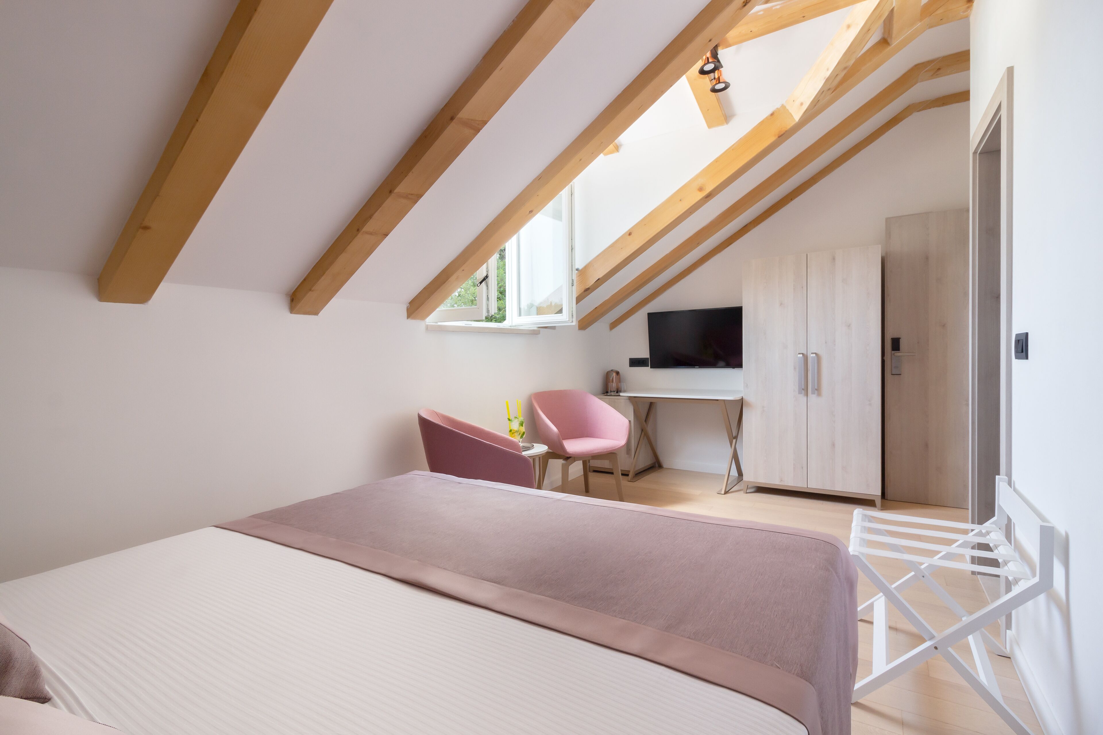 A bedroom with a bed, a desk, a chair, and a wardrobe.