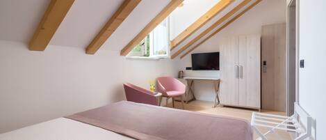 A bedroom with a bed, a desk, a chair, and a wardrobe.
