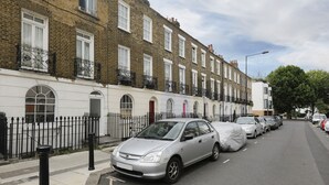 A row of terraced houses with a parked car in front. - Cozy Apartment in Camden Town (London)