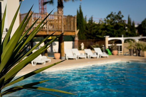 Outdoor pool, open 10:00 AM to 7:00 PM, pool loungers