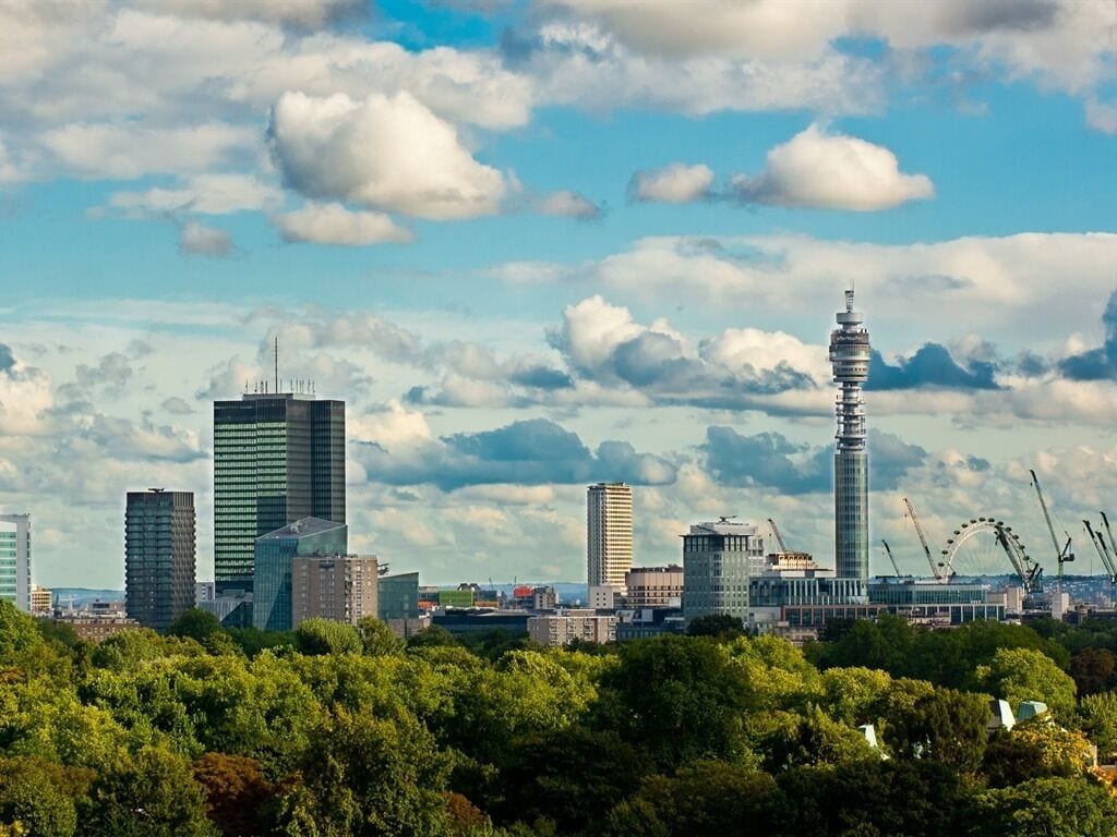 Stadsbeeld met moderne gebouwen, waaronder een opvallende toren en een reuzenrad op de achtergrond.