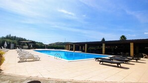 A swimming pool with lounge chairs and a covered seating area. - Amarcord (Spezzano Albanese)