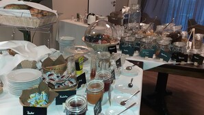 A buffet table with various food items, including bread, pastries, and condiments. - Hotel Marco Polo (Münster)