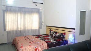 A bedroom with a bed, a nightstand, a lamp, and a ceiling fan. - Tourist Castle Hotel and Suites (Calabar)