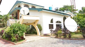 A modern house with satellite dishes, a water tank, and a well-maintained garden. - Tourist Castle Hotel and Suites (Calabar)