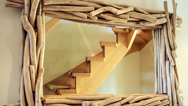 A wooden staircase with a rustic design, surrounded by a wooden frame. - House Friesenperle - House Friesenperle Whg 01 (Sankt Peter-Ording)