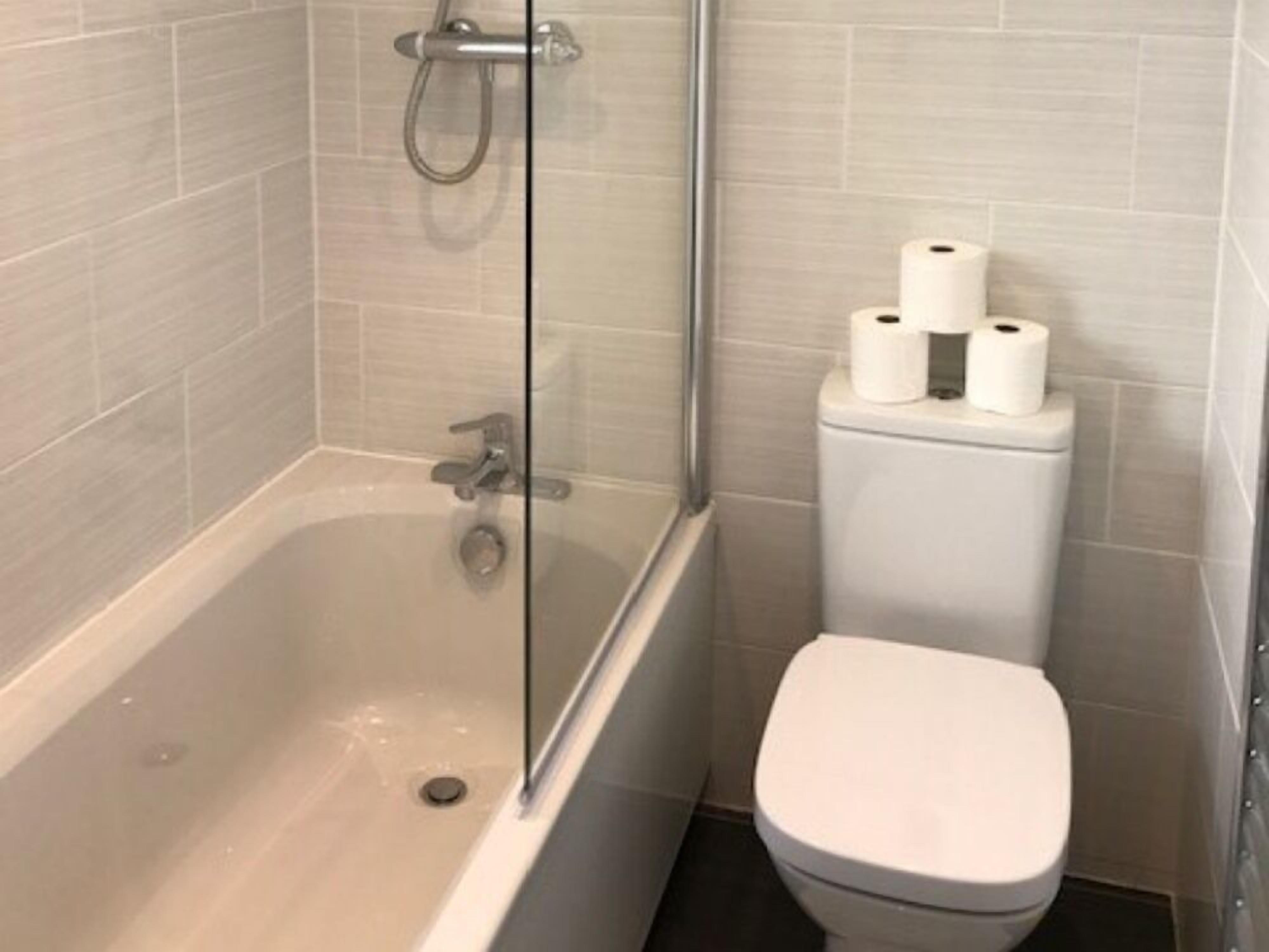 Une salle de bain avec une baignoire, des toilettes et une douche à parois de verre.