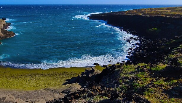 Un paisaje costero con acantilados, una playa y el océano.