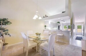 Enjoy meals in a spacious dining area with a glass-top table and comfortable seating.