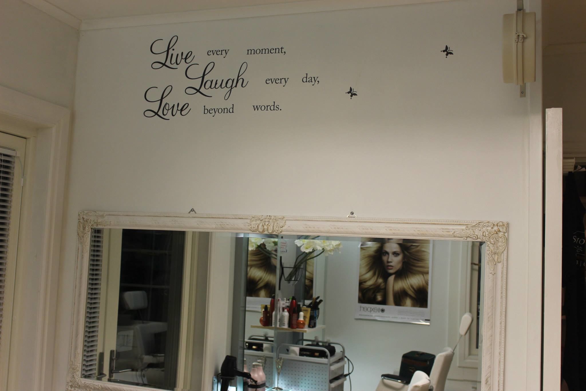 Una habitación con un espejo grande, un tocador con artículos de aseo y una cita inspiradora en la pared.
