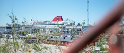 A cruise ship docked at a port with multiple decks and a prominent red 'G' on the tail.