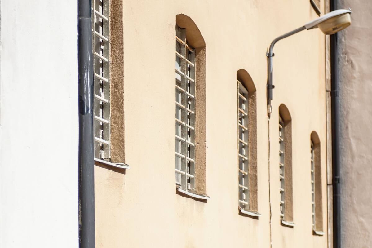 A building facade with multiple arched windows and a street lamp.