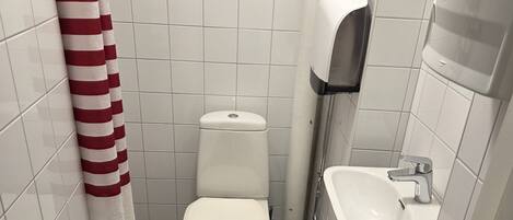 Ein kleines Badezimmer mit Toilette, Waschbecken und Handtrockner.