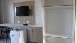 A modern kitchenette with a built-in microwave, a small refrigerator, and a flat-screen TV mounted on the wall. - Locanda Dei Venti (Itarema)