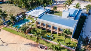 An aerial view of a resort with a swimming pool, palm trees, and a beach. - Locanda Dei Venti (Itarema)