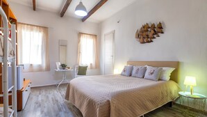 Un dormitorio con cama, mesita de noche, lámpara y un adorno en la pared.