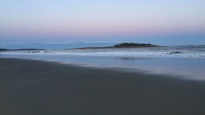 En strand med en liten ö i fjärran.