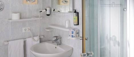 Une salle de bain moderne avec une douche à parois de verre, un lavabo, des toilettes et un porte-serviettes.