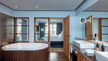 Ein modernes Badezimmer mit einer großen Badewanne, zwei Waschbecken und einem Spiegel.