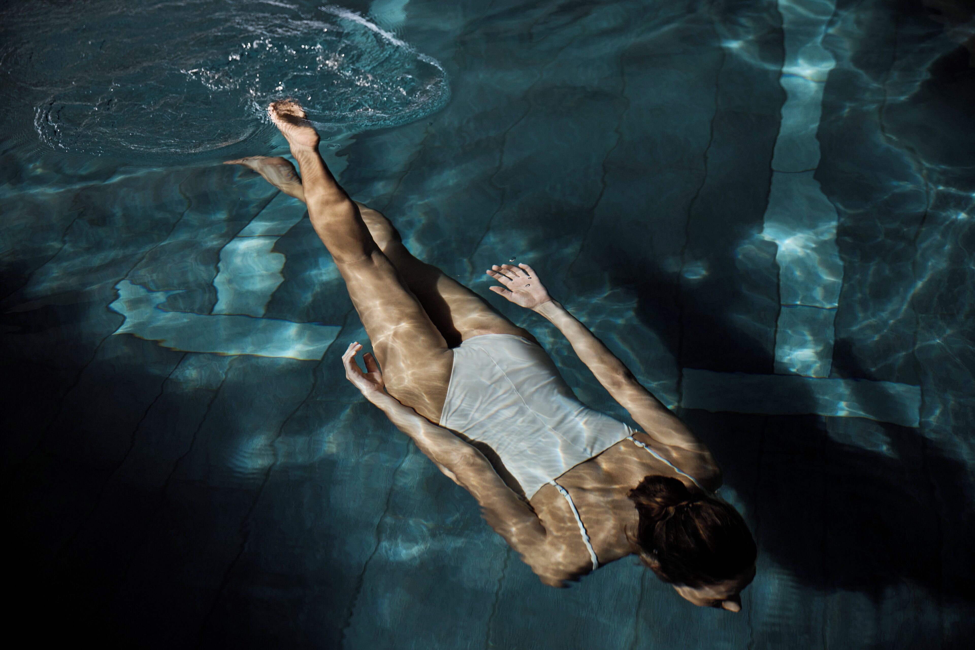 Una persona nadando en una piscina.